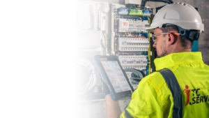 Elektrotechnik pracující v rozvaděči s pojistkami. Instalace a připojení elektrických zařízení.